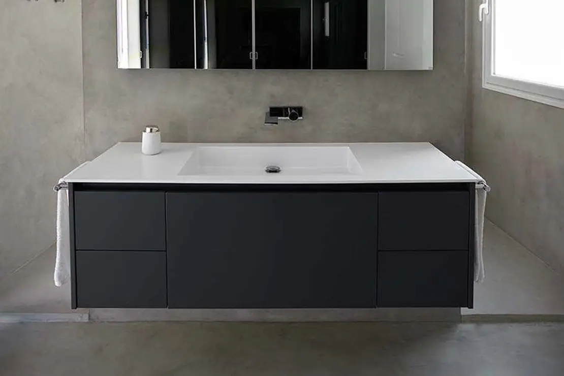 Baño de microcemento con suelo, muros y regadera de tonalidad gris.